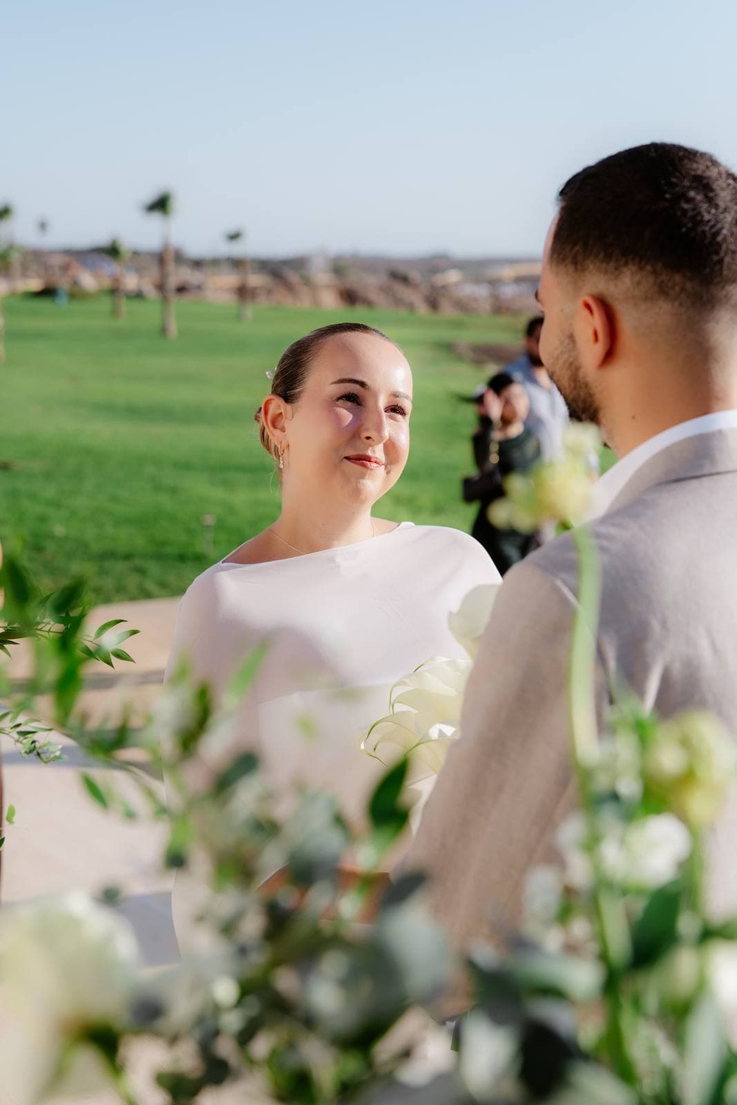 Christos & Eleni, the bride smiling at the groom during the ceremony