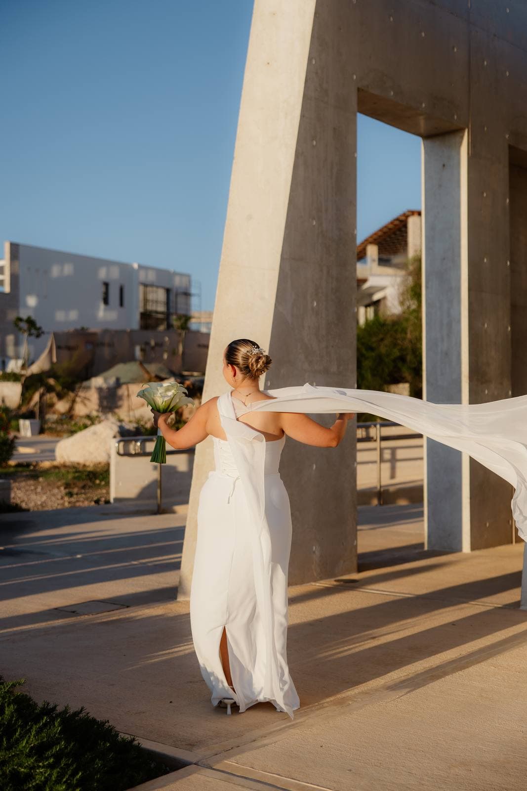 Christos & Eleni, the bride's cape against the chapel wall