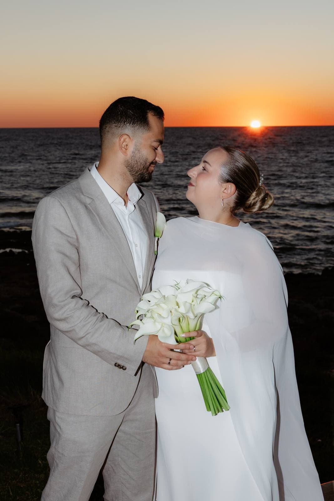 Christos & Eleni, the groom holding the bride at sunset