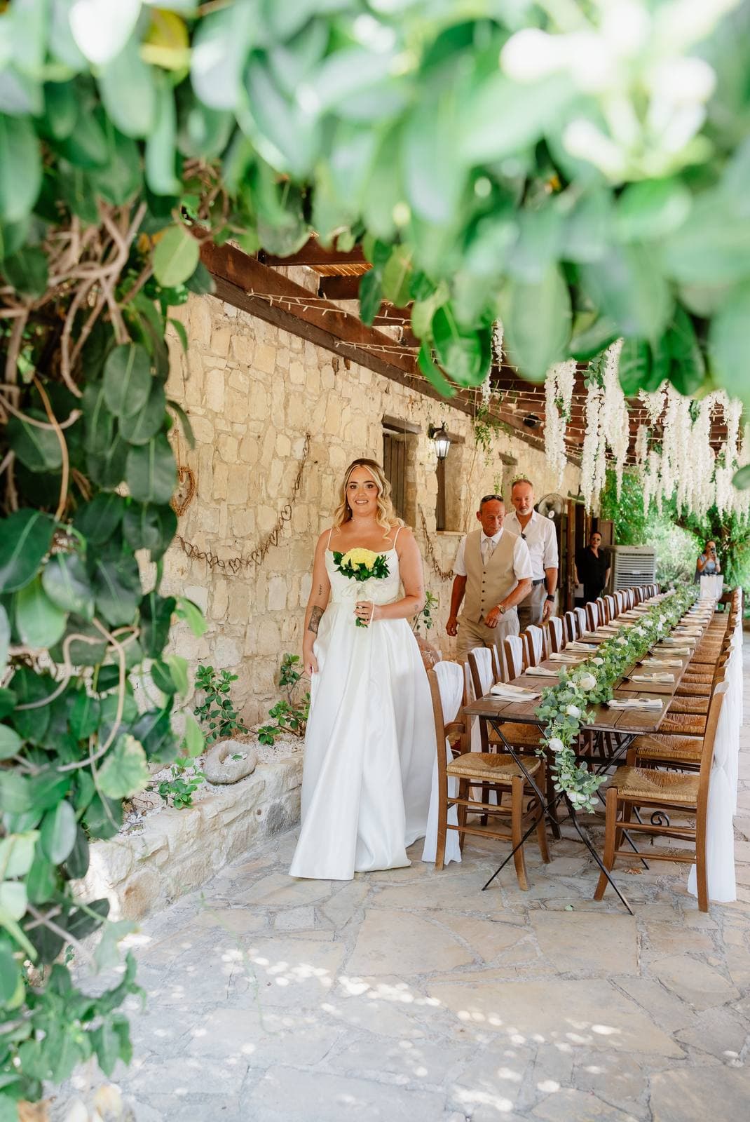 Hannah & Danial, the bride under the vines by the dinner tables