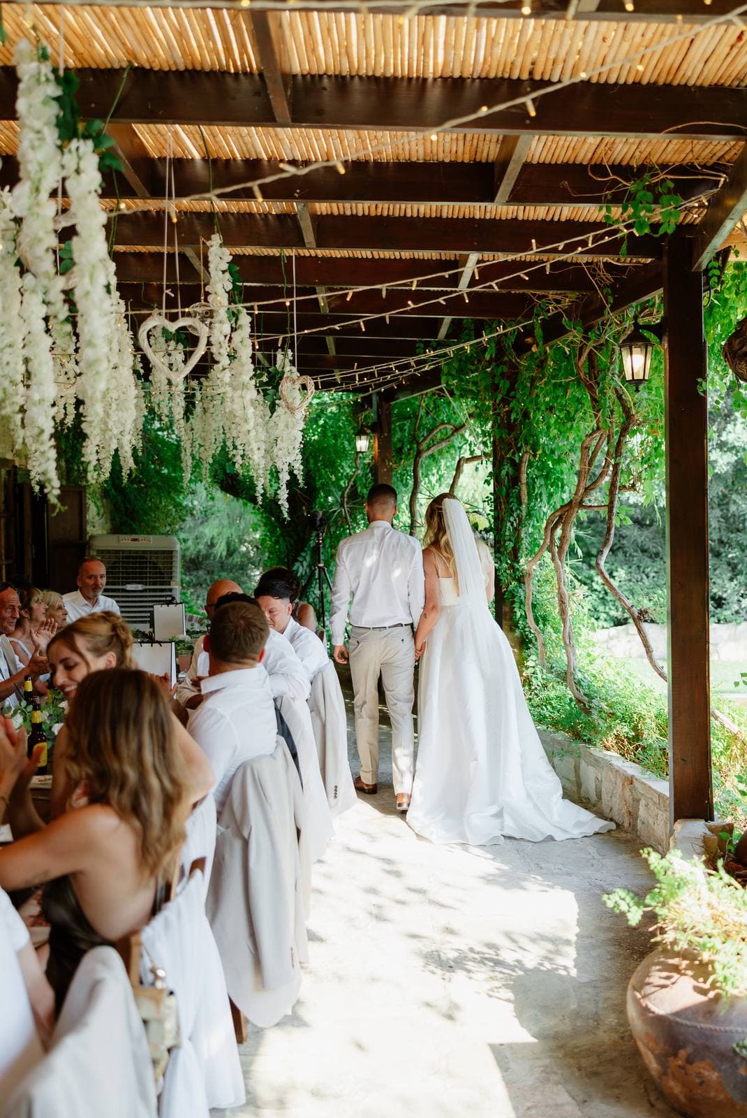 Hannah & Danial, bride and groom arriving at dinner under the wisteria