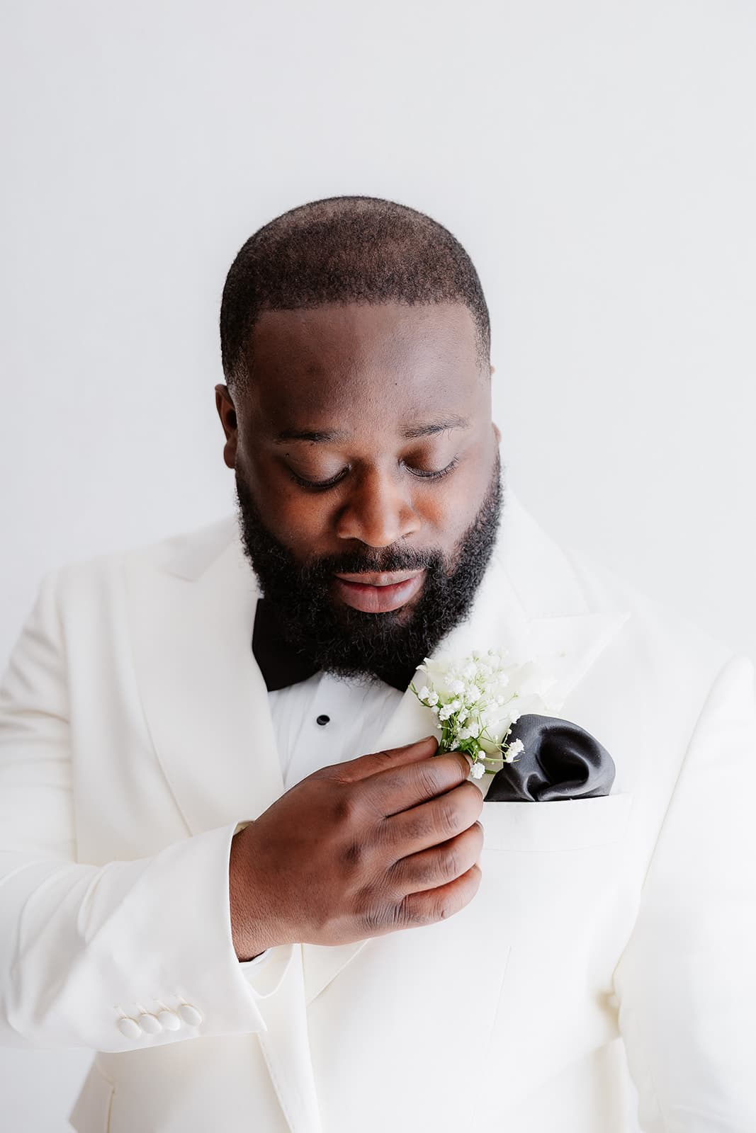 Groom fastening his buttonhole