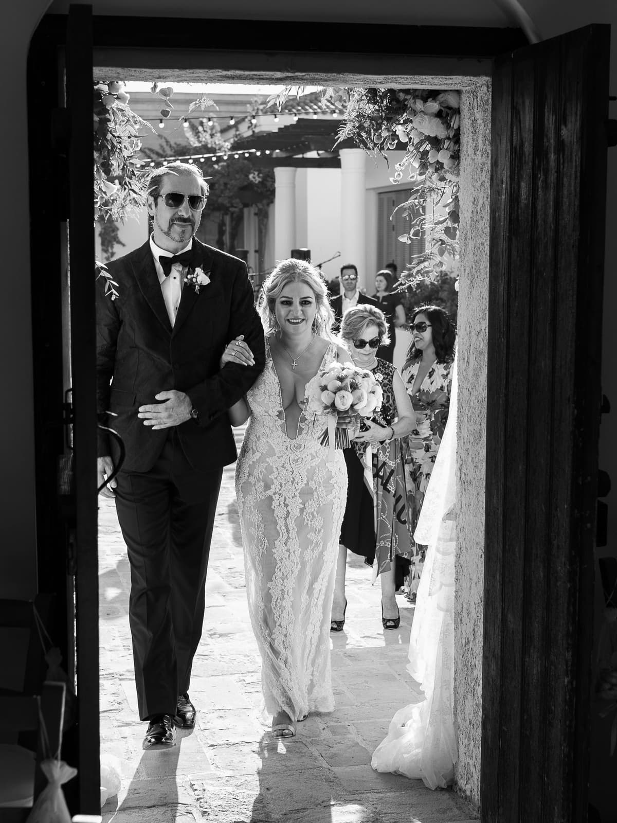 The bride walks into the Anassa chapel on her father's arm