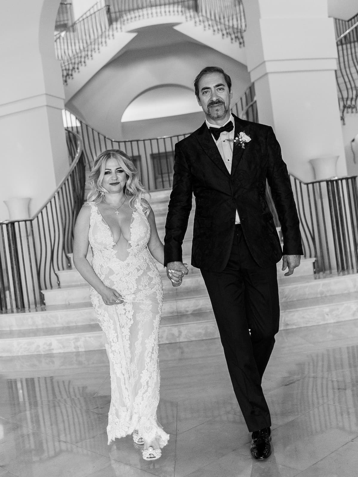 The couple walking down the Anassa staircase