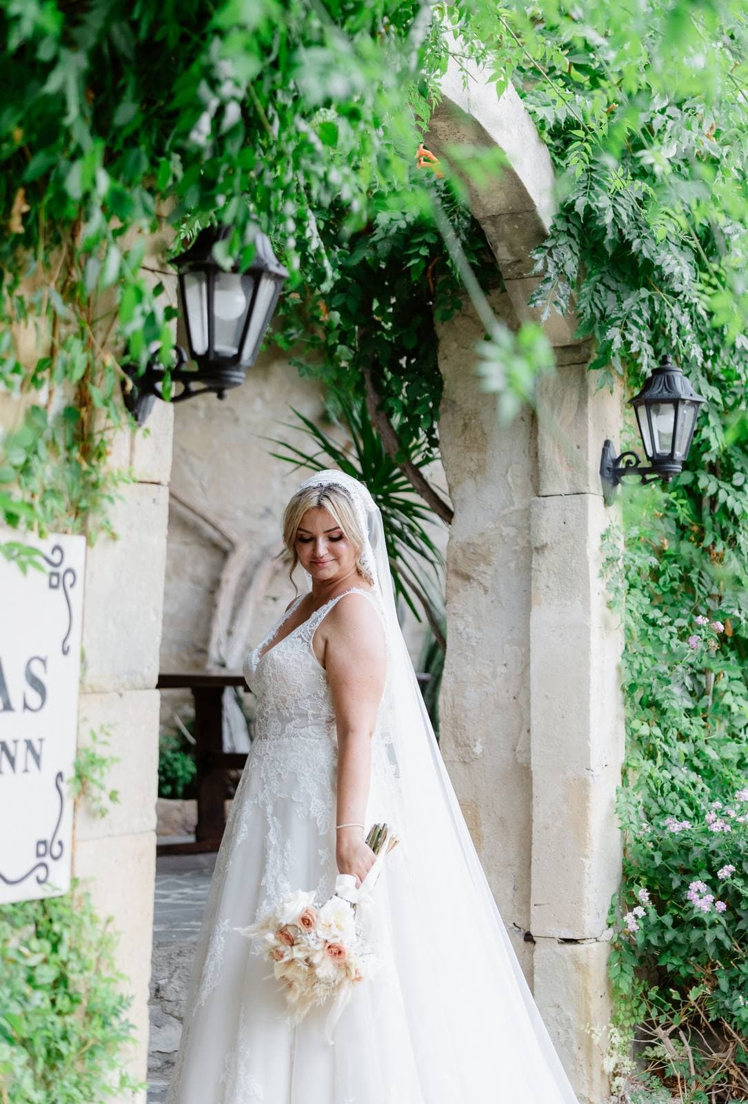 Rita & Andrej, the bride at the inn's ivy-covered gate