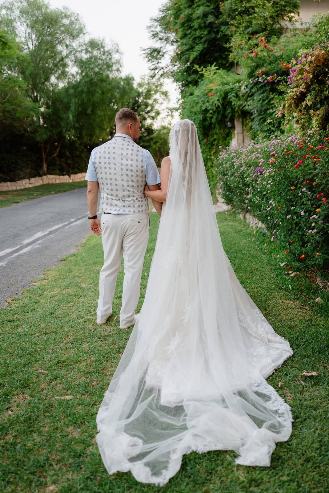 Rita & Andrej, walking along the lane, the veil trailing behind
