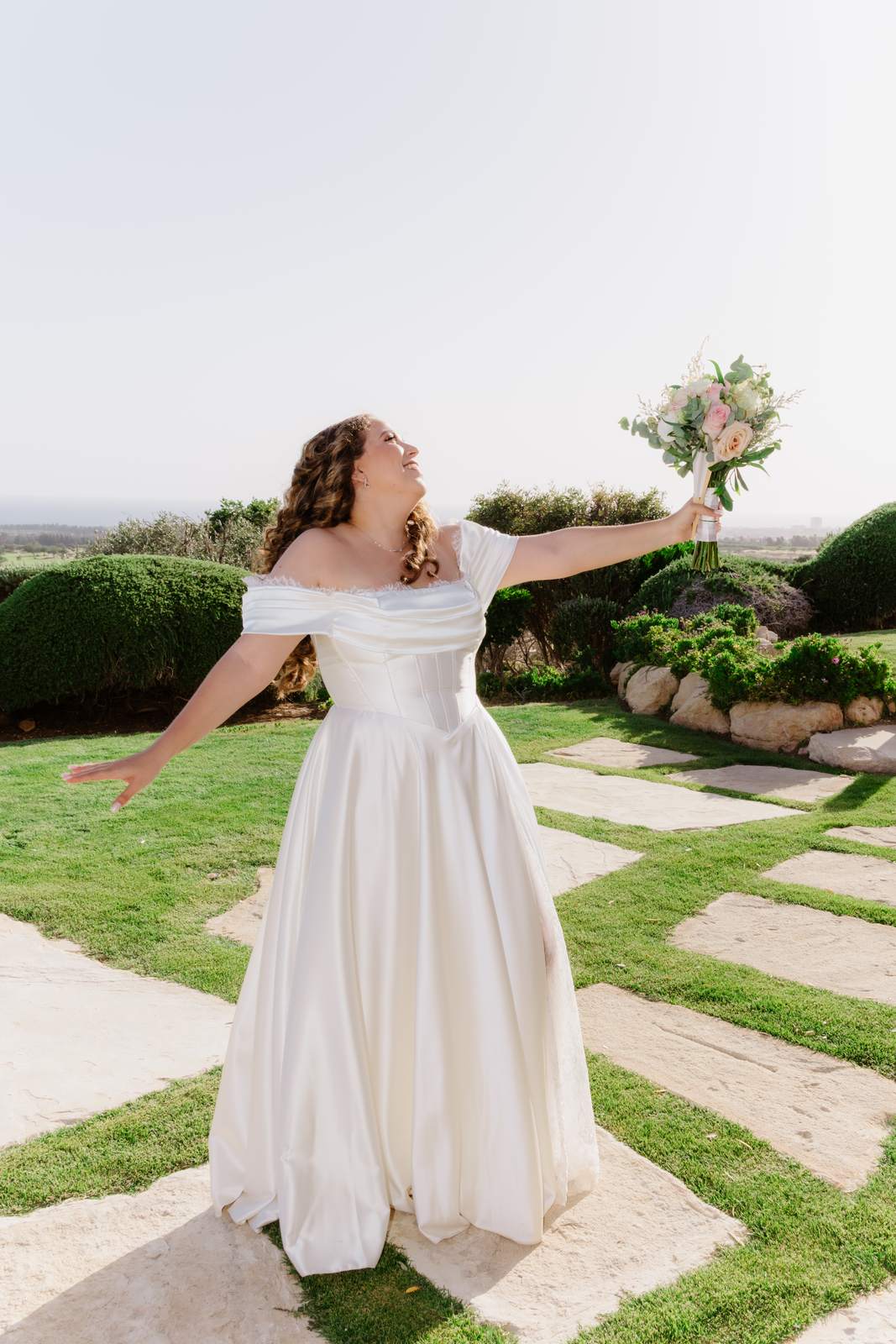 Sivan & Elon, the bride with her arms open over the golf course